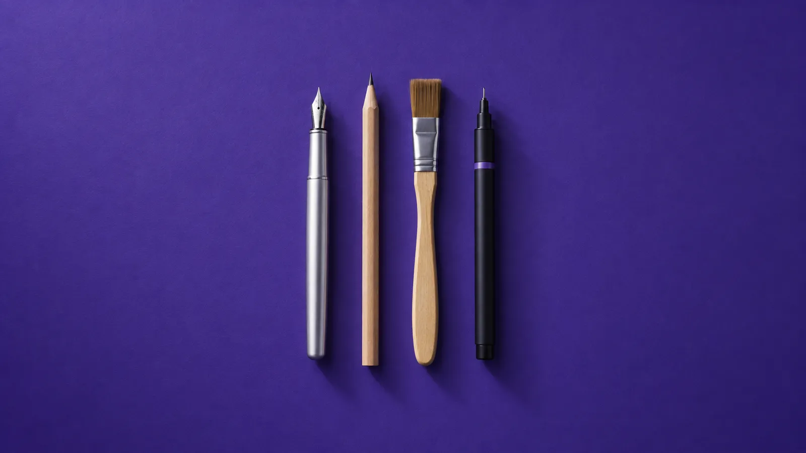 Caneta-tinteiro, lápis, pincel e caneta técnica lado a lado, sobre papel violeta